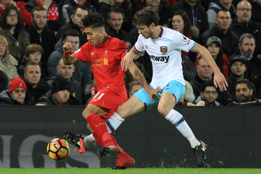 Liverpool's Brazilian midfielder Roberto Firmino (L0 vies with West Ham United's Norwegian midfielder Havard Nordtveit during the English Premier League football match between Liverpool and West Ham United at Anfield in Liverpool, north west England on December 11, 2016. / AFP PHOTO / Lindsey PARNABY / RESTRICTED TO EDITORIAL USE. No use with unauthorized audio, video, data, fixture lists, club/league logos or 'live' services. Online in-match use limited to 75 images, no video emulation. No use in betting, games or single club/league/player publications.  /