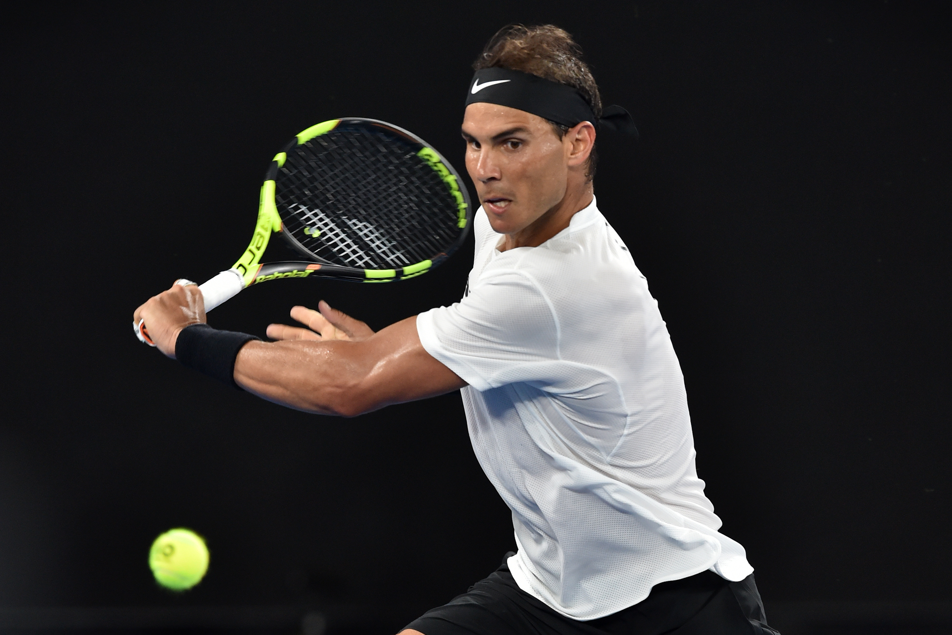 Spain's Rafael Nadal hits a return against Cyprus's Marcos Baghdatis during their men's singles second round match on day four of the Australian Open tennis tournament in Melbourne on January 19, 2017. / AFP PHOTO / PAUL CROCK / IMAGE RESTRICTED TO EDITORIAL USE - STRICTLY NO COMMERCIAL USE
