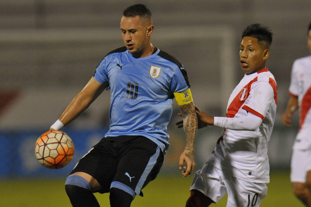 Uruguay's  player Rodrigo Amaral (L) vies for the ball with Peru's player Raul Tito during their South American Championship U-20 football match at the Olimpico stadium in Ibarra, Ecuador on January 25, 2017. / AFP PHOTO / JUAN CEVALLOS