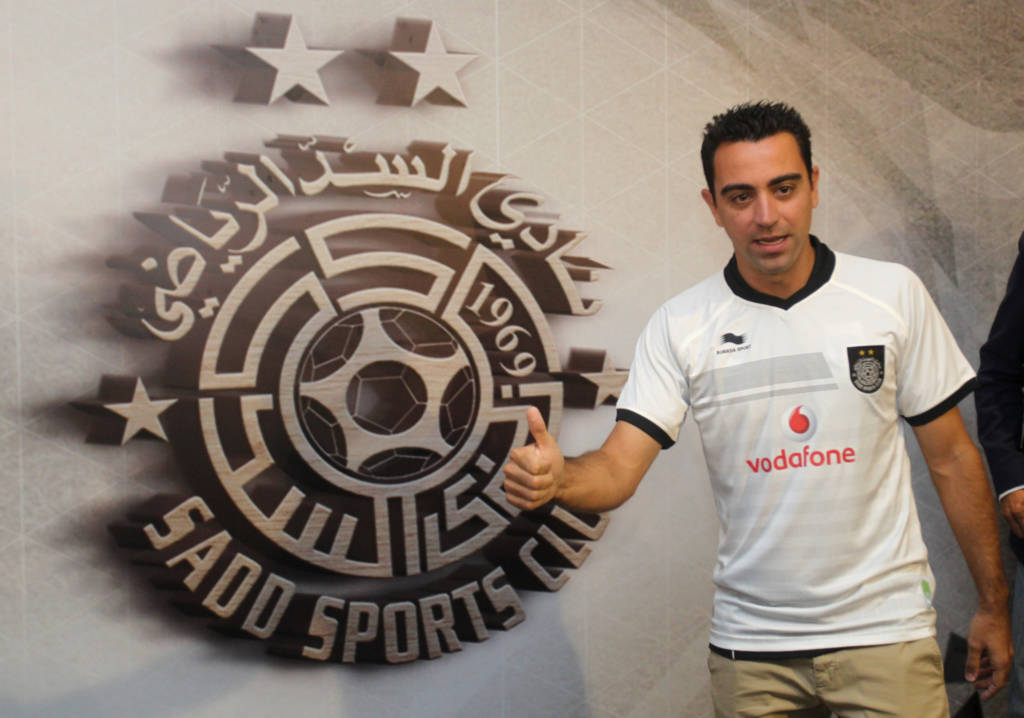 (FILES) This file photo taken on June 11, 2015 shows Barcelona legend Xavi Hernandez posing for a photo in his new Al-Sadd shirt after signing a two-year contract with the Qatari team in Doha. Barcelona great Xavi Hernandez has agreed a year's extension to his contract with Qatar's Al Sadd, according to a statement posted on the club's website on January 26, 2017. / AFP PHOTO / STRINGER
