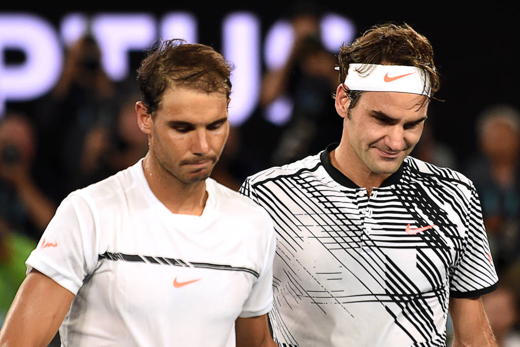 Switzerland's Roger Federer (R) walks off the court with Spain's Rafael Nadal after winning their men's singles final match on day 14 of the Australian Open tennis tournament in Melbourne on January 29, 2017. / AFP PHOTO / PAUL CROCK / IMAGE RESTRICTED TO EDITORIAL USE - STRICTLY NO COMMERCIAL USE