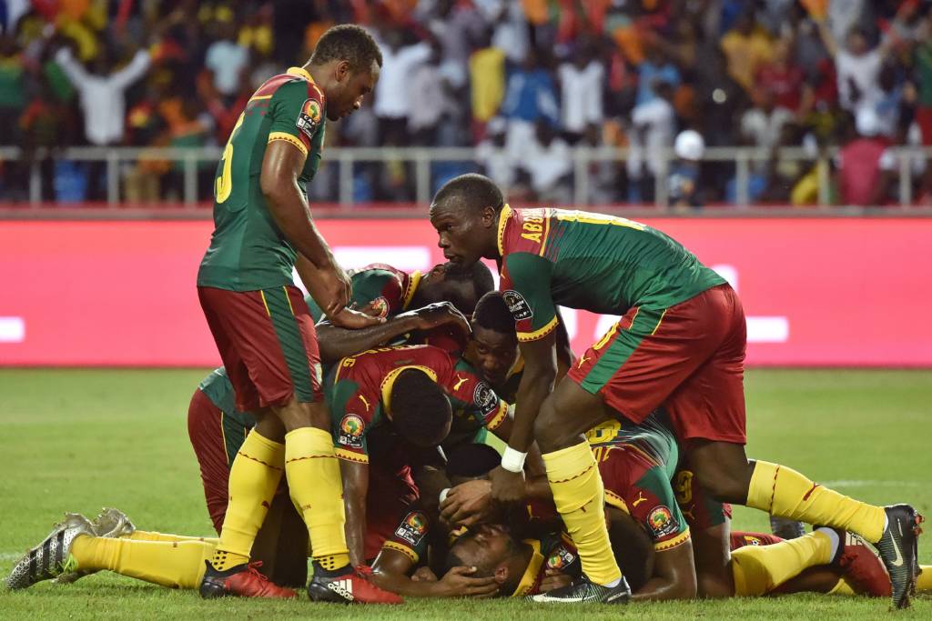 Cameroon players celebrate their first goal scored by Cameroon's defender Nicolas Nkoulou (ground) during the 2017 Africa Cup of Nations final football match between Egypt and Cameroon at the Stade de l'Amitie Sino-Gabonaise in Libreville on February 5, 2017. / AFP PHOTO / ISSOUF SANOGO