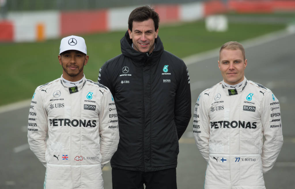 Mercedes AMG Petronas Formula One drivers Britain's Lewis Hamilton (L) and Finland's Valtteri Bottas (R) pose with Mercedes head Austria's Toto Wolff by the new 2017 season Mercedes W08 EQ Power+ Formula One car at its launch event at Silverstone motor racing circuit near Towcester, central England on February 23, 2017. / AFP PHOTO / OLI SCARFF