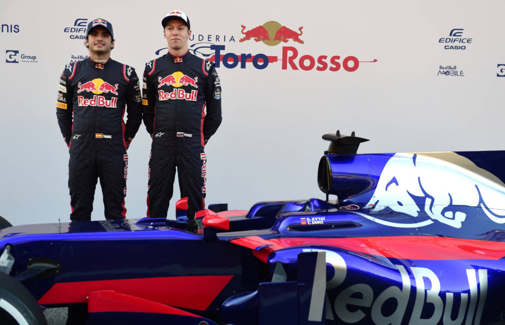Scuderia Toro Rosso's Russian driver Daniil Kvyat (R) and Spanish driver Carlos Sainz pose by their new STR12 car during their official presentation at the Circuit de Catalunya on February 26, 2017 in Montmelo on the outskirts of Barcelona. / AFP PHOTO / Jose Jordan