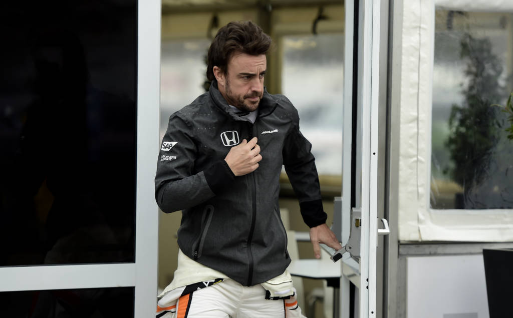 McLaren Honda's Spanish driver Fernando Alonso walks on the pit lane drives at the Circuit de Catalunya on March 1, 2017 in Montmelo on the outskirts of Barcelona during the third day of the first week of tests for the Formula One Grand Prix season. / AFP PHOTO / JOSE JORDAN