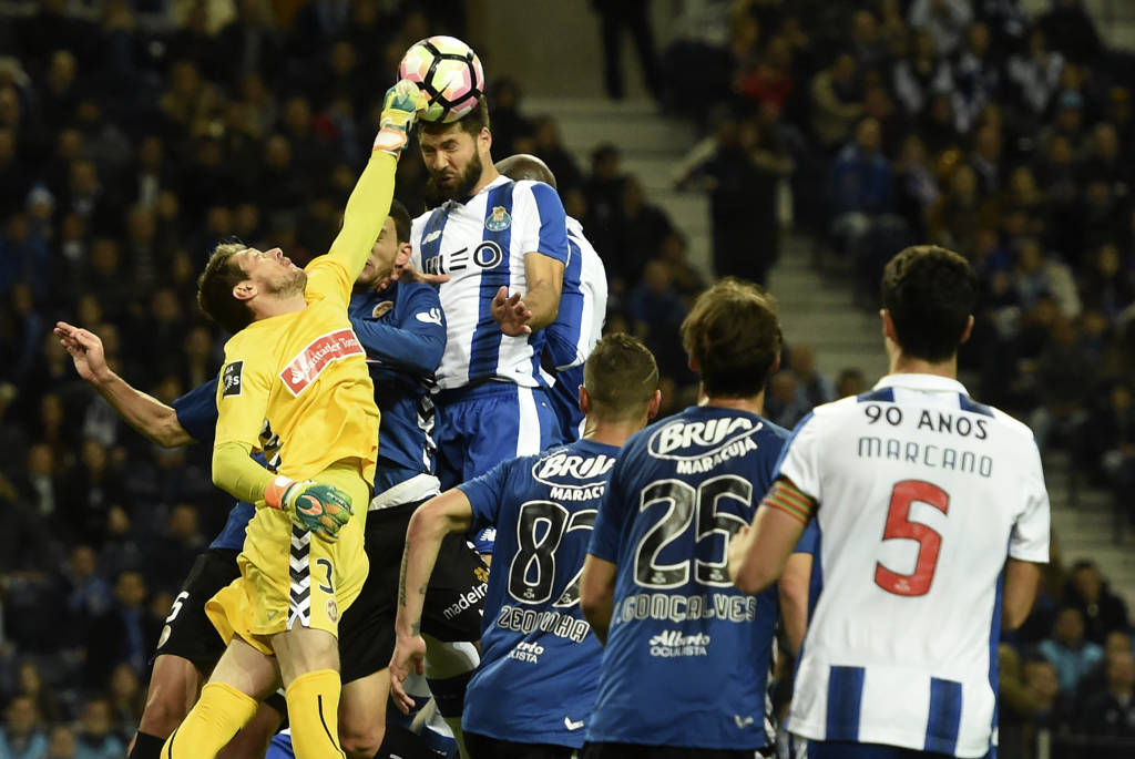 Nacional's Brazilian goalkeeper Adriano Facchini (L) vies with Porto's Brazilian defender Felipe (top) during the Portuguese league football match FC Porto vs CD Nacional Funchal at the Dragao stadium in Porto on March 4, 2017. / AFP PHOTO / FRANCISCO LEONG