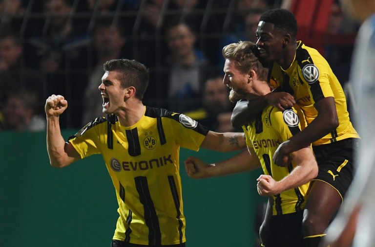 Dortmund's midfielder Andre Schuerrle (C) scoring with his teammates during the German Cup DFB Pokal quarter-final football match Sportfreunde Lotte v BVB Borussia Dortmund, in Osnabruck, northern Germany on March 14, 2017. / AFP PHOTO / PATRIK STOLLARZ / RESTRICTIONS: ACCORDING TO DFB RULES IMAGE SEQUENCES TO SIMULATE VIDEO IS NOT ALLOWED DURING MATCH TIME. MOBILE (MMS) USE IS NOT ALLOWED DURING AND FOR FURTHER TWO HOURS AFTER THE MATCH. == RESTRICTED TO EDITORIAL USE == FOR MORE INFORMATION CONTACT DFB DIRECTLY AT +49 69 67880  /