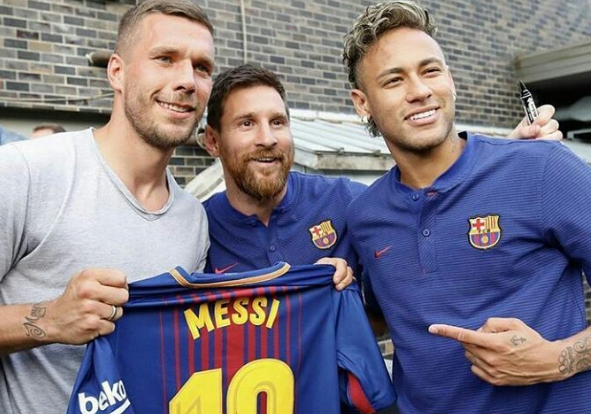 No Japão, Podolski ganha camisa autografada de Messi e Neymar